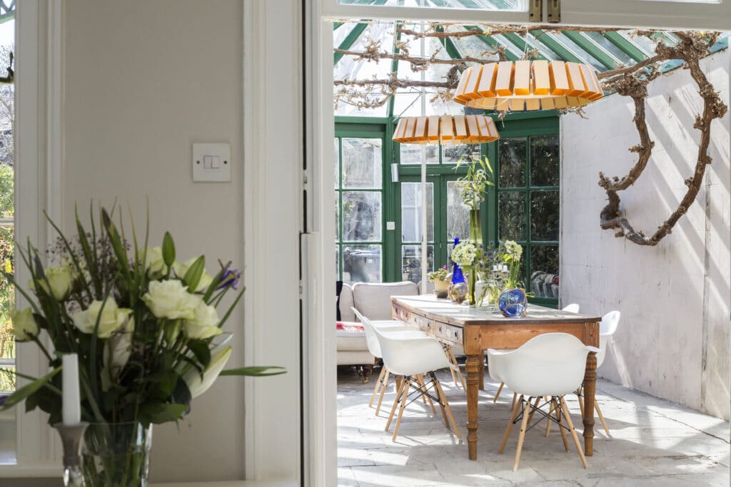 a room filled with furniture and vase of flowers on a table
