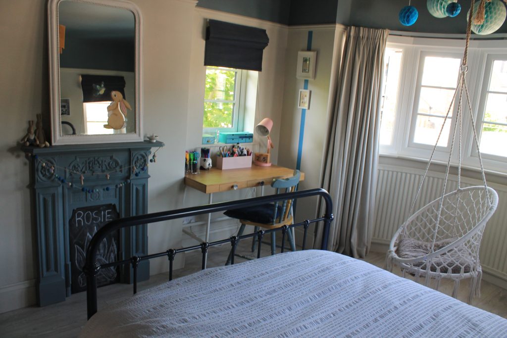a bedroom with a bed and a chair in front of a window