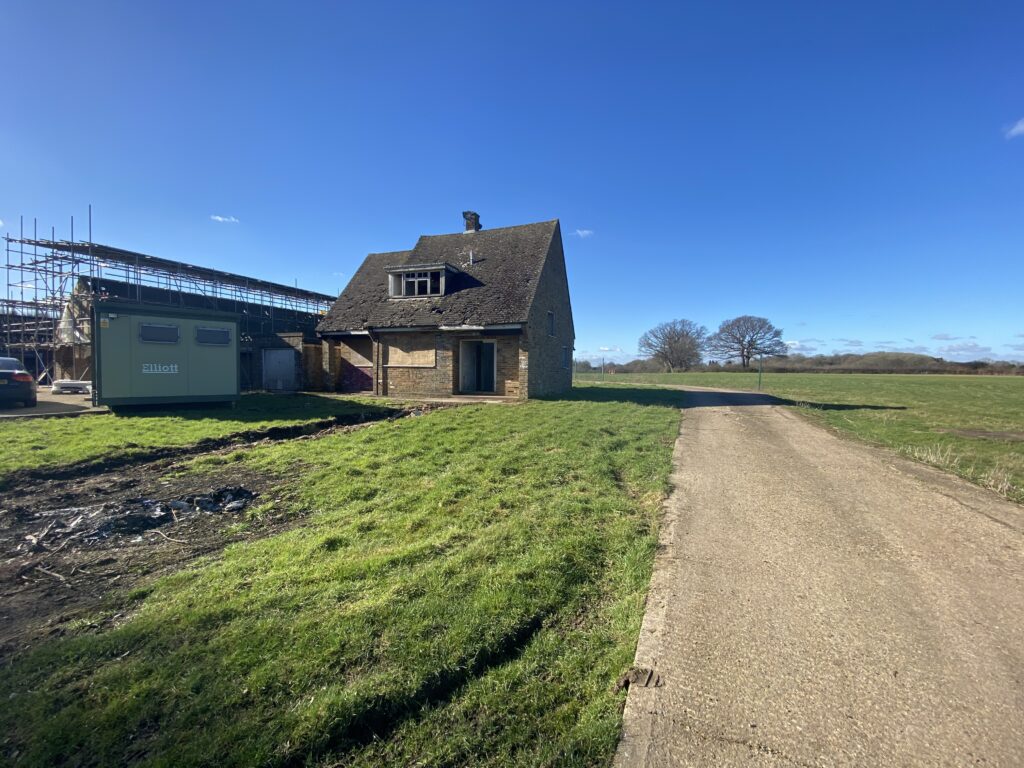 a dirt road with trees on the side of a building