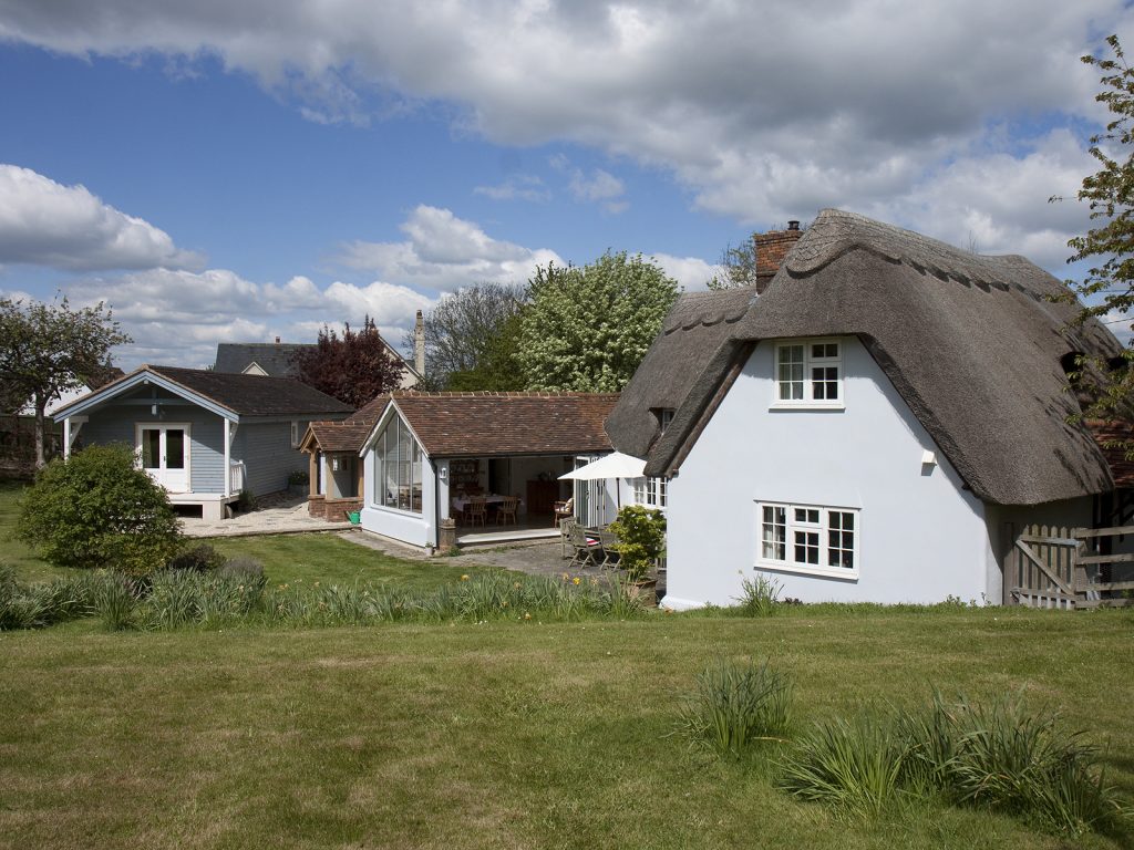 a large brick building with grass in front of a house