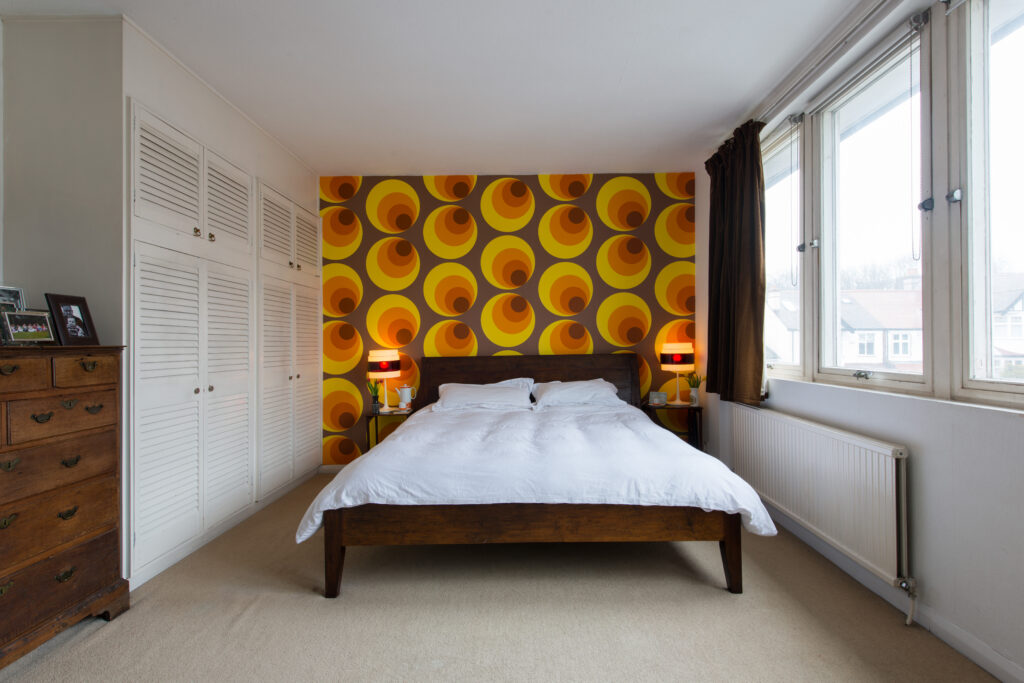 a bedroom with a bed and desk in a room