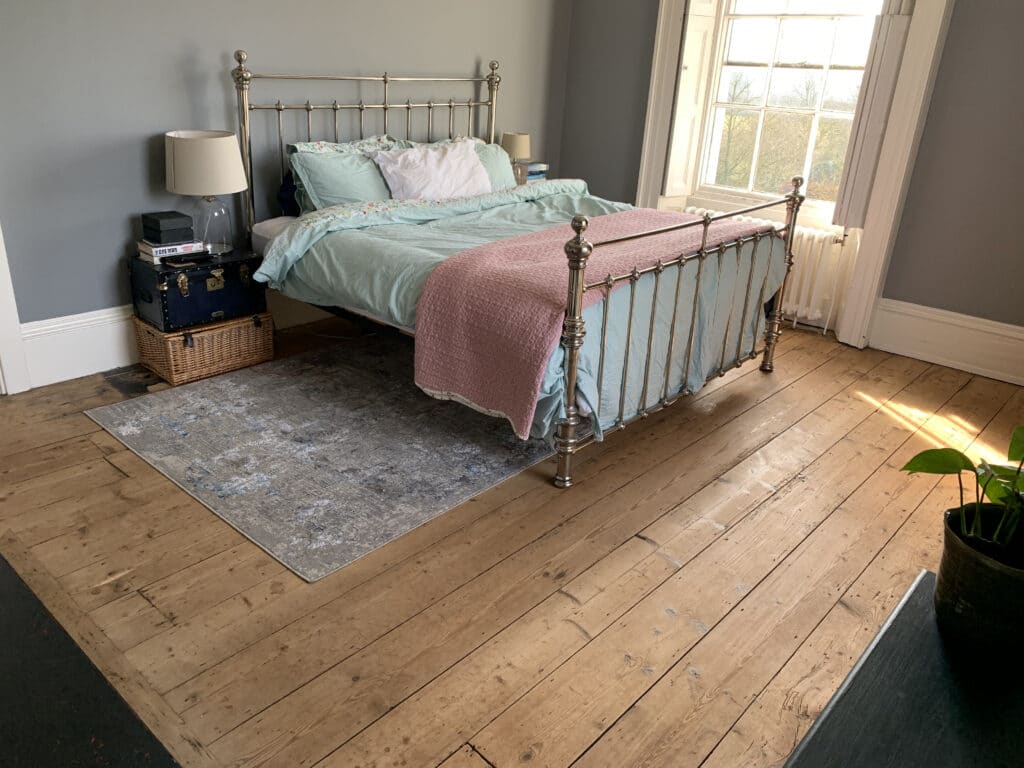 a bedroom with a bed and a chair in a room