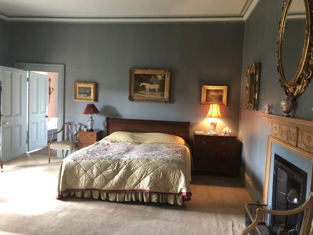 a bedroom with a bed and desk in a room