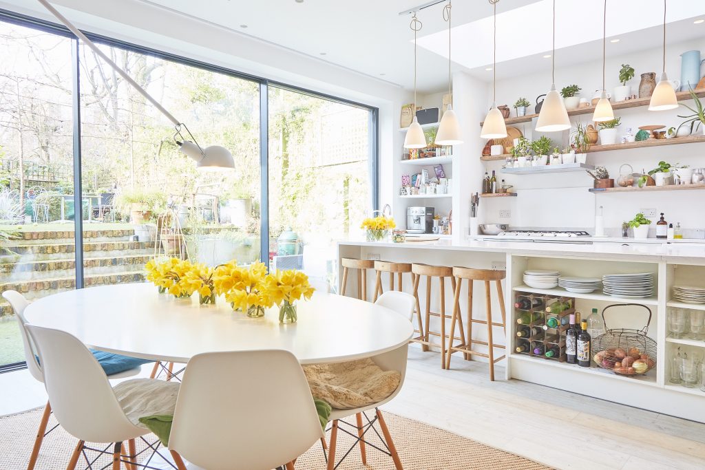 a room filled with furniture and vase of flowers on a table