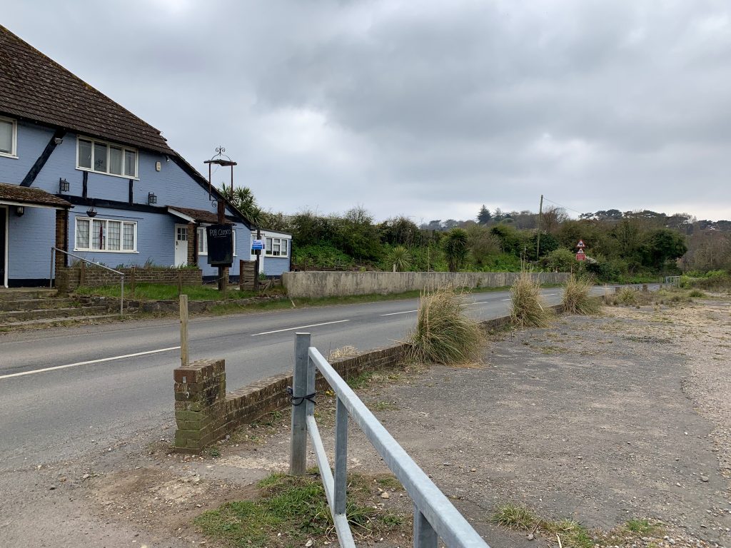 a house that has a sign on the side of a road