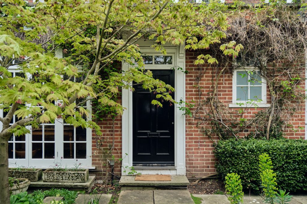 a house with bushes in front of a brick building