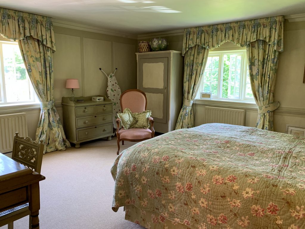 a bedroom with a bed and a chair in a room