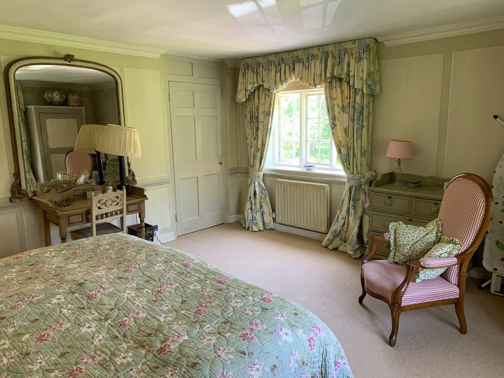 a bedroom with a bed and a chair in a room