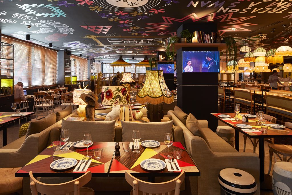 a living room filled with furniture and a table in a restaurant