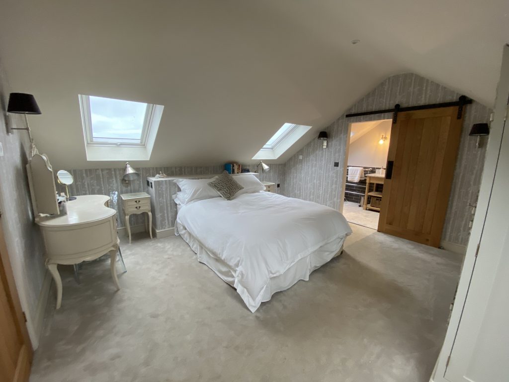 a bedroom with a bed and desk in a room