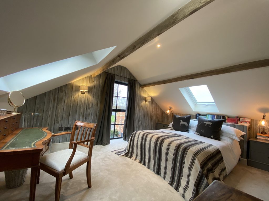 a bedroom with a bed and a chair in a room