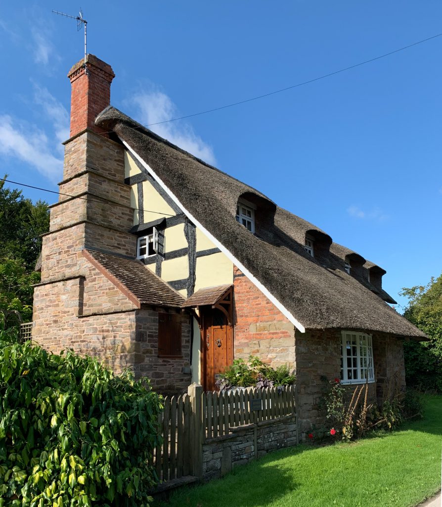 a large brick building with grass in front of a house
