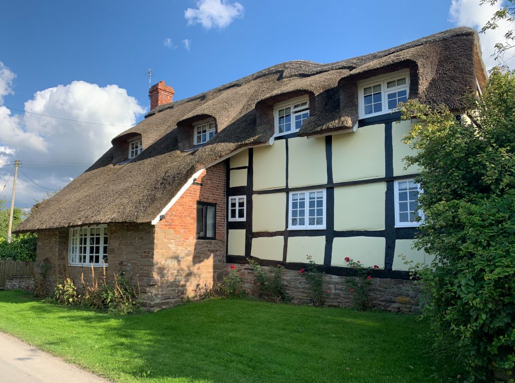 a large brick building with grass in front of a house