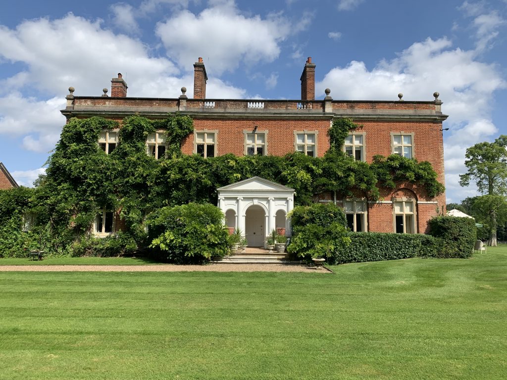 a large brick building with a grassy field