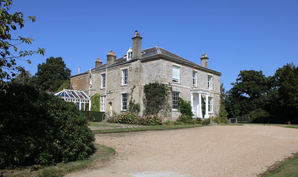 a large brick building with grass in front of a house