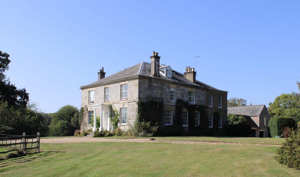 a large brick building with grass in front of a house