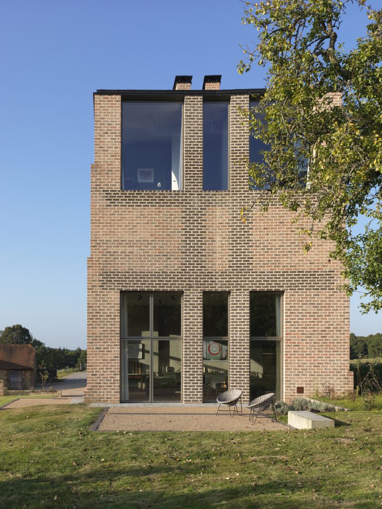 a large brick building with grass in front of a house