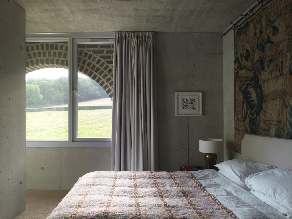 a bedroom with a bed and a large window