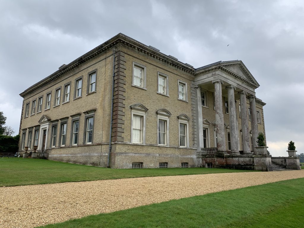 a large stone building with a grassy field