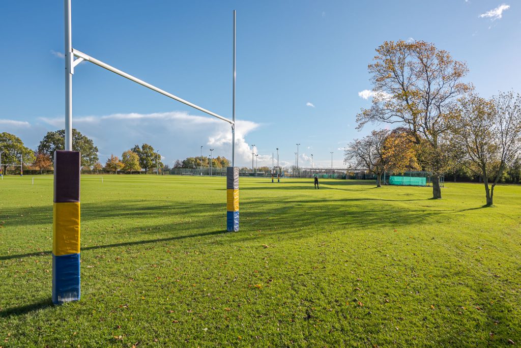 a pole that has a sign on a grassy field