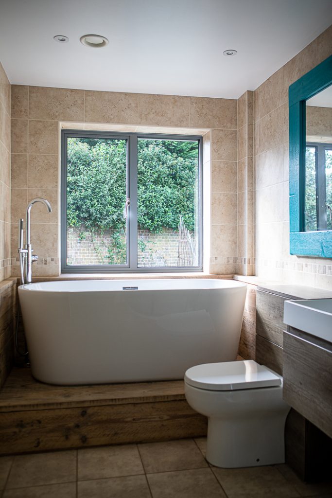a room with a large tub next to a window