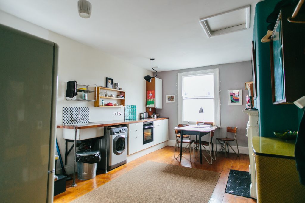 a kitchen with a refrigerator and table in a room