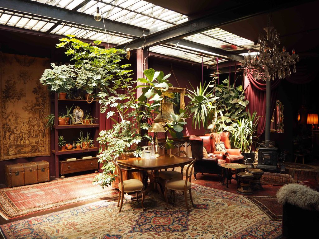 a room filled with furniture and vase of flowers on a table