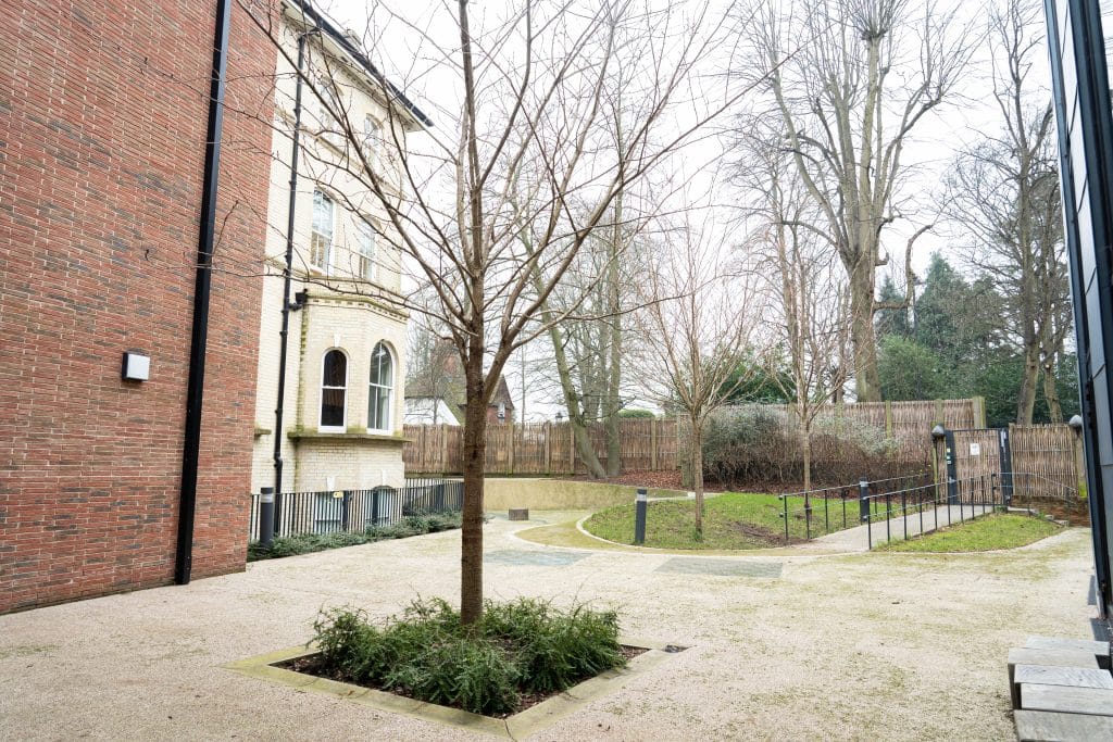 a large brick building with grass and trees