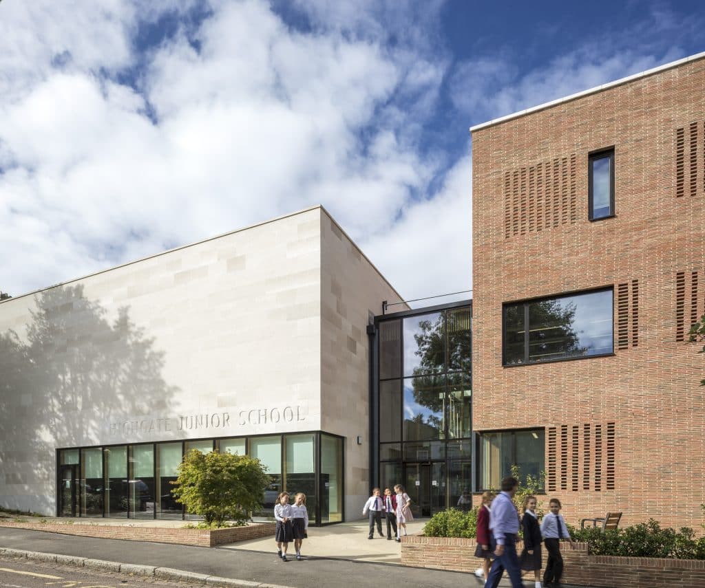 a group of people walking in front of a brick building