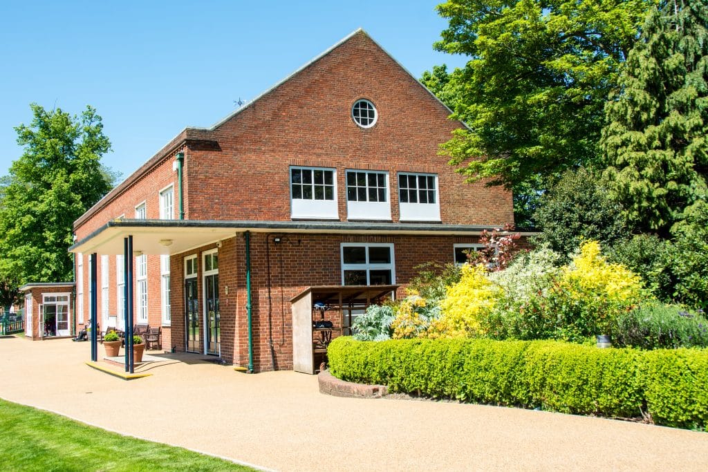 a large brick building with grass in front of a house