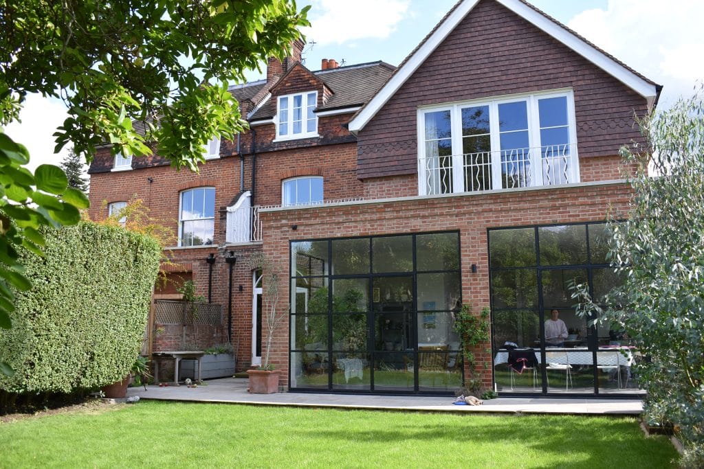 a large brick building with grass in front of a house