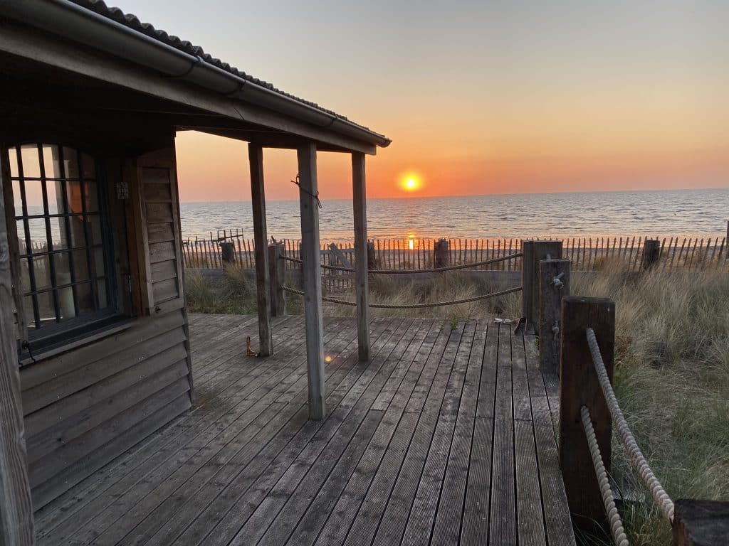 a beach with a pier in front of a body of water