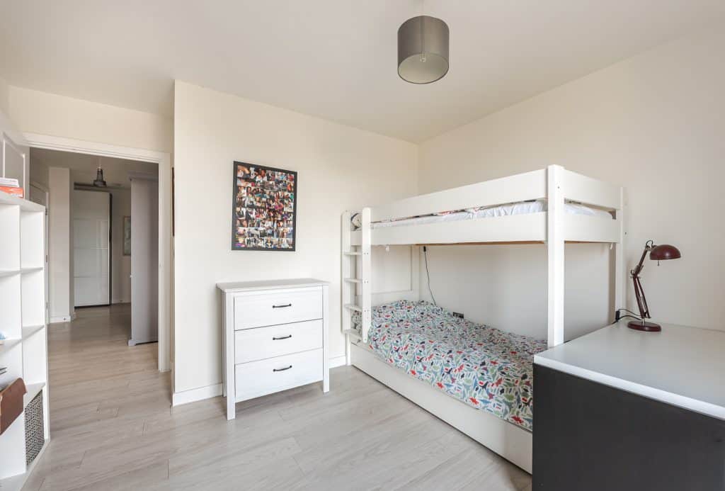 a bedroom with a bed and a mirror in a room