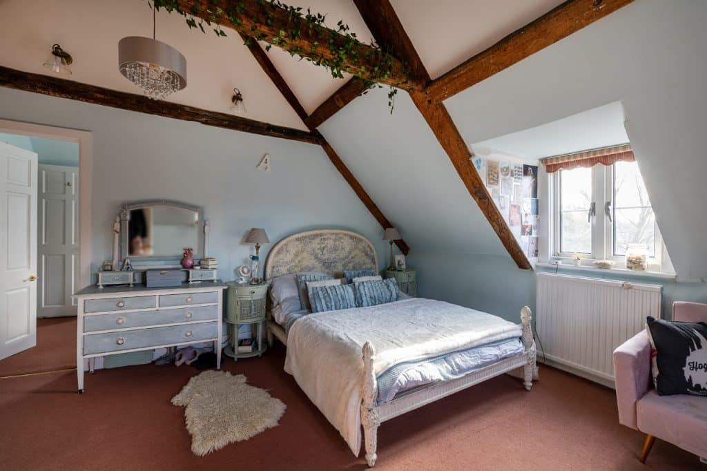 a bedroom with a bed and desk in a room