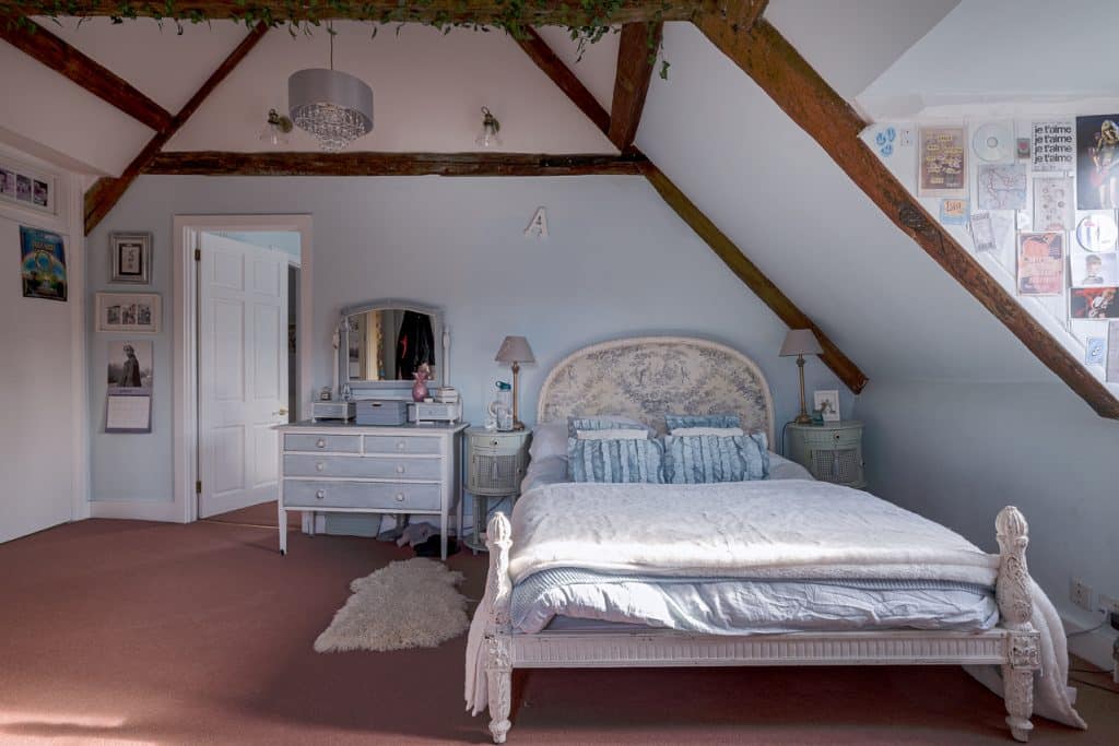 a bedroom with a bed and desk in a room