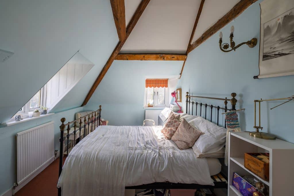 a bedroom with a bed and desk in a room