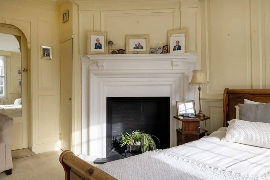 a bedroom with a bed and a chair in a room
