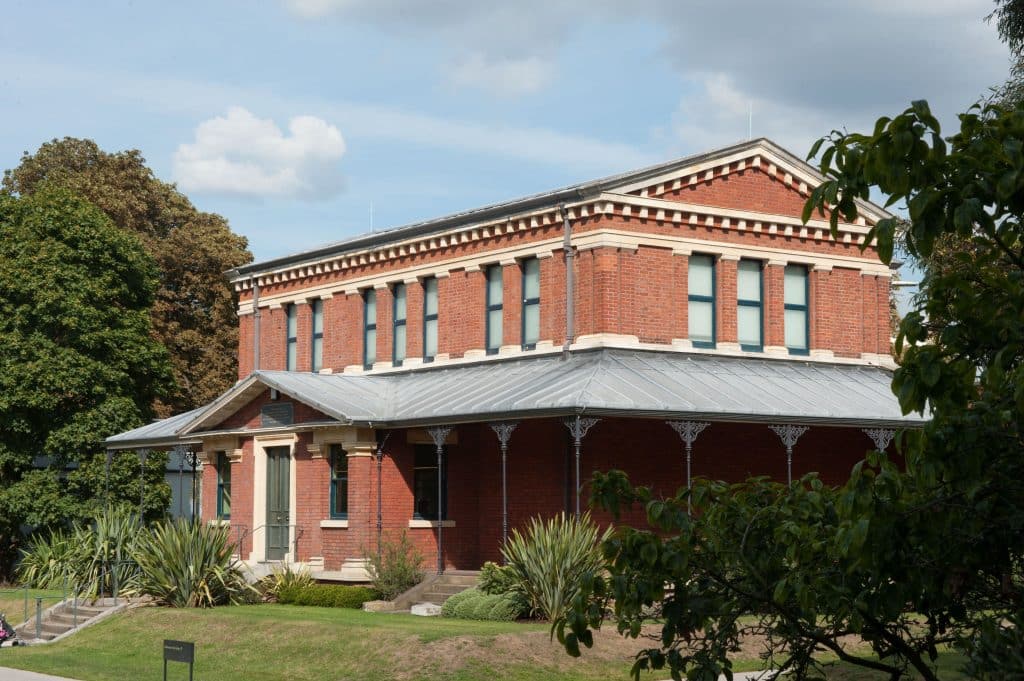 a house with bushes in front of a brick building