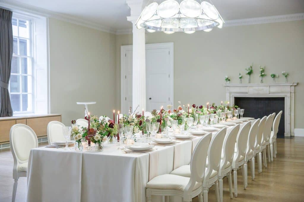 a room filled with furniture and vase of flowers on a table