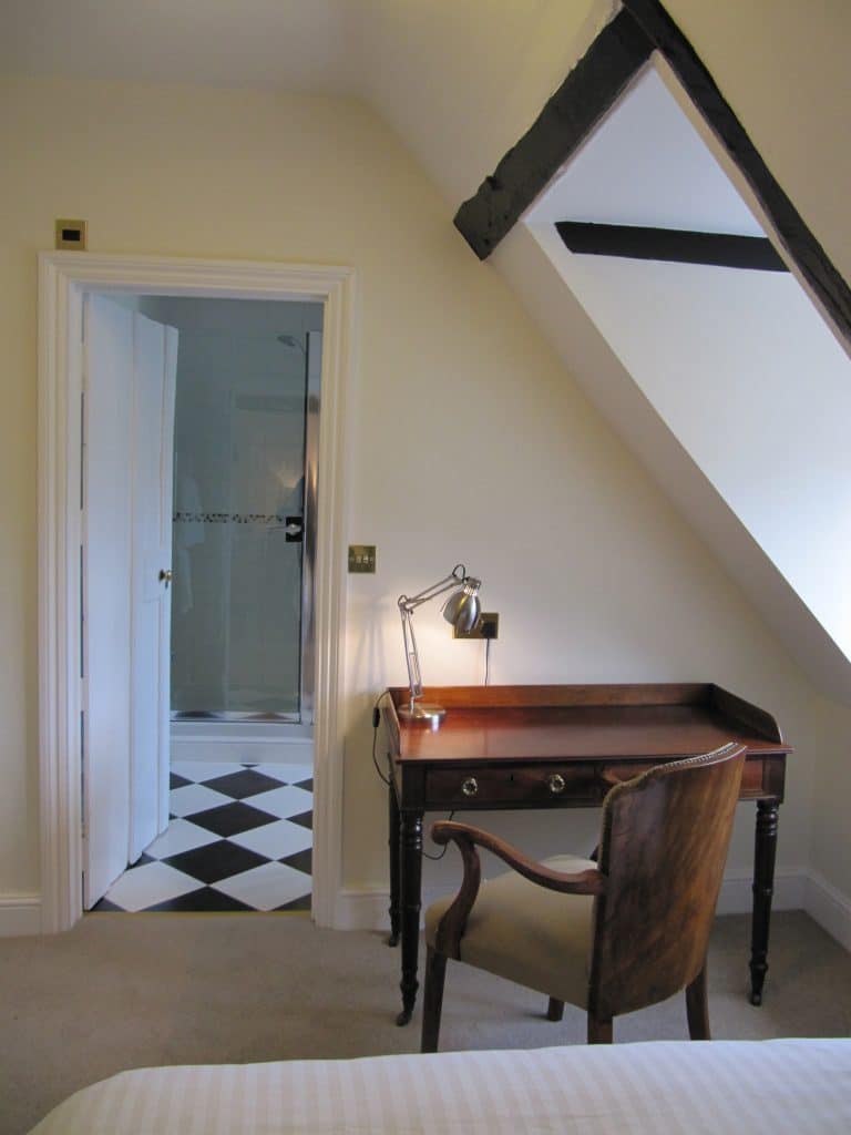 a bedroom with a bed and a mirror in a room