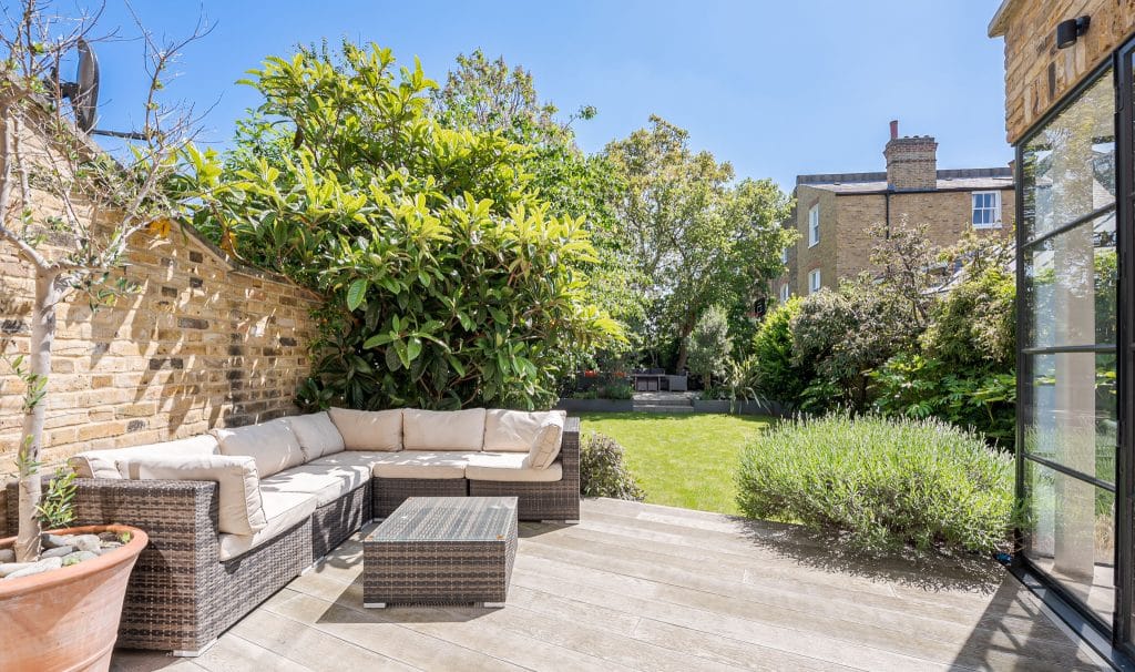 a stone building that has a bench in a garden