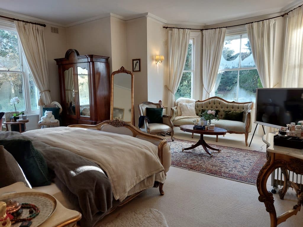 a bedroom with a bed and a chair in a room