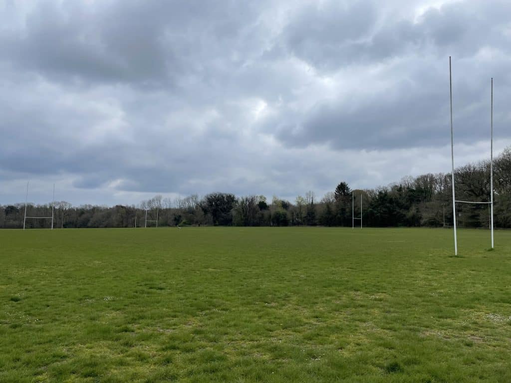 a large green field under a cloudy sky