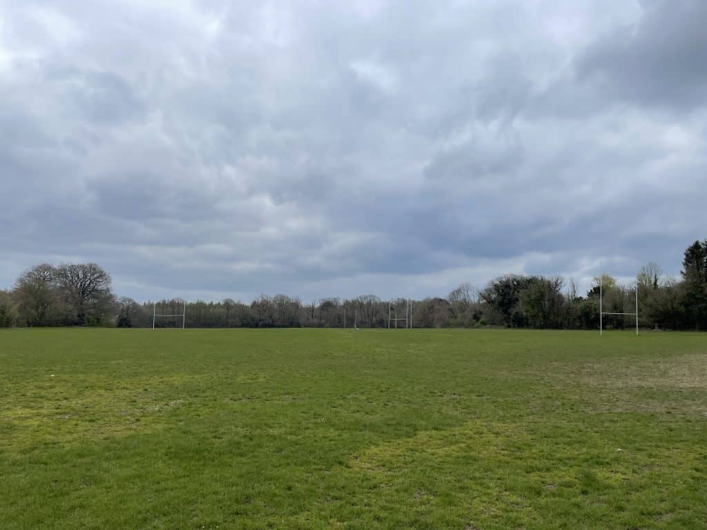a large green field under a cloudy sky