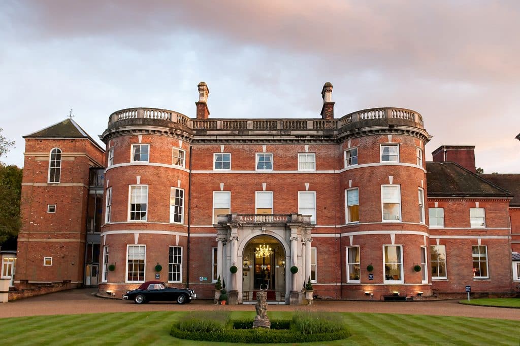 a large brick building with grass in front of a castle