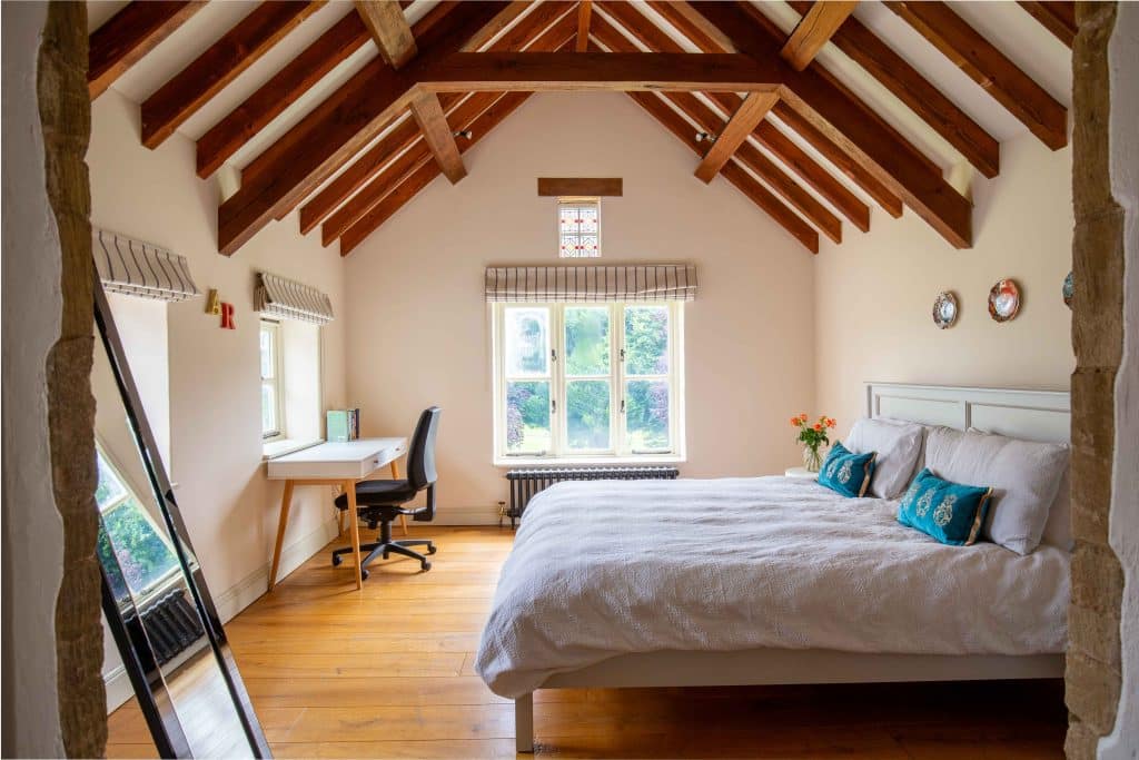 a bedroom with a bed and a chair in a room