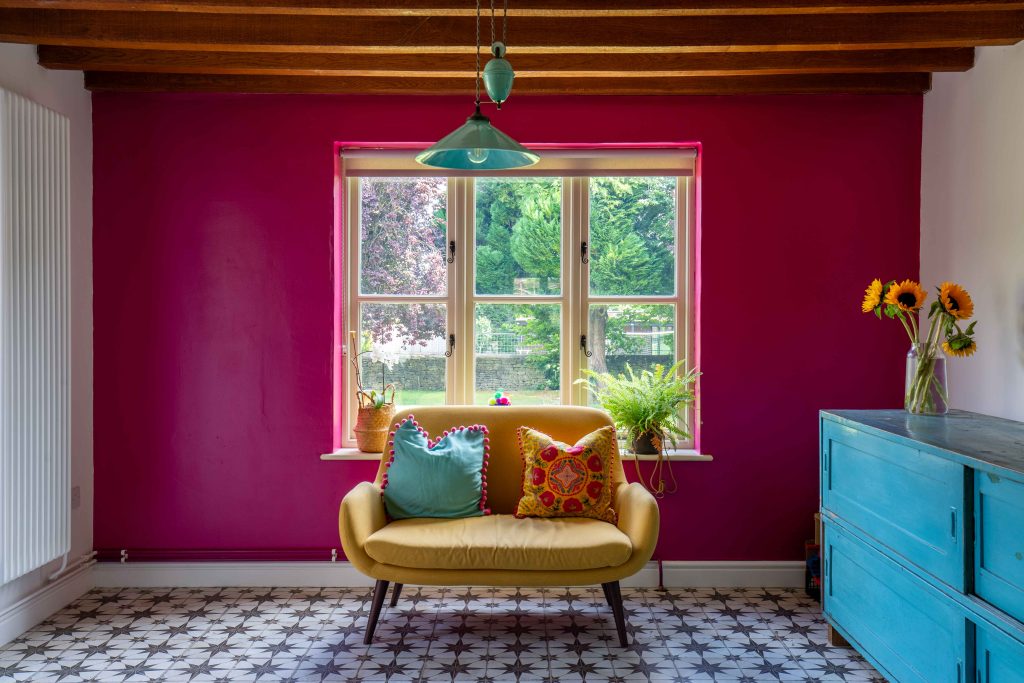 a room with a couch and a chair in front of a window