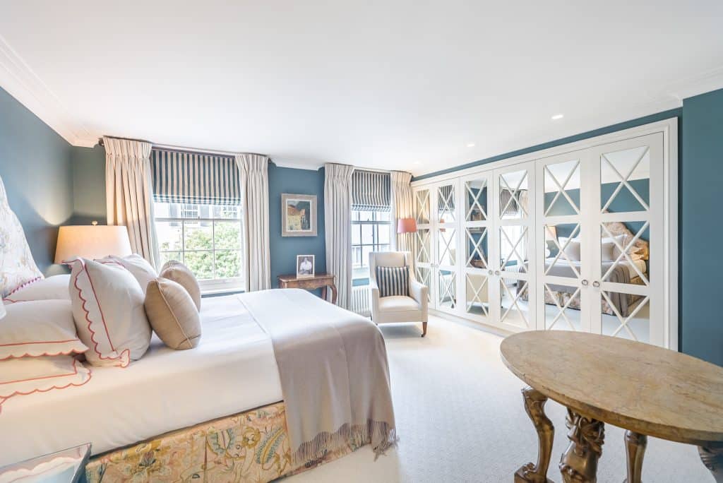 a bedroom with a bed and a chair in a room
