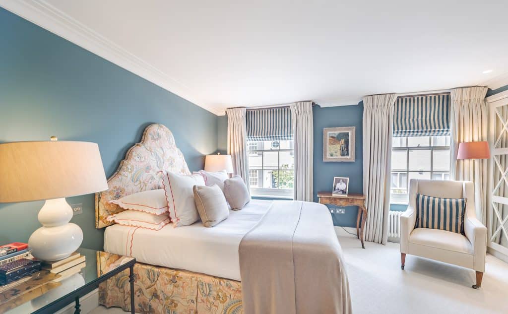 a bedroom with a bed and a chair in a living room