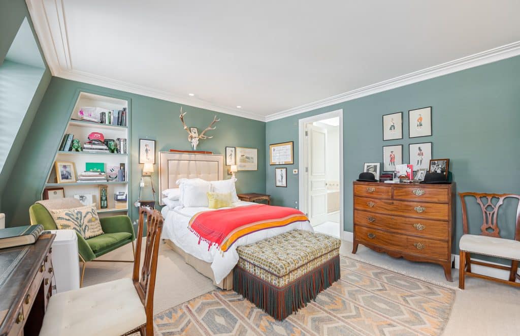 a bedroom with a bed and a chair in a room
